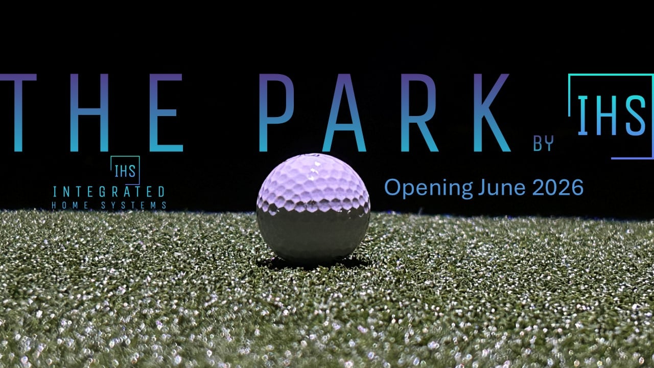 The Park by IHS golf course opening June 2026, featuring a purple golf ball on artificial turf with project branding